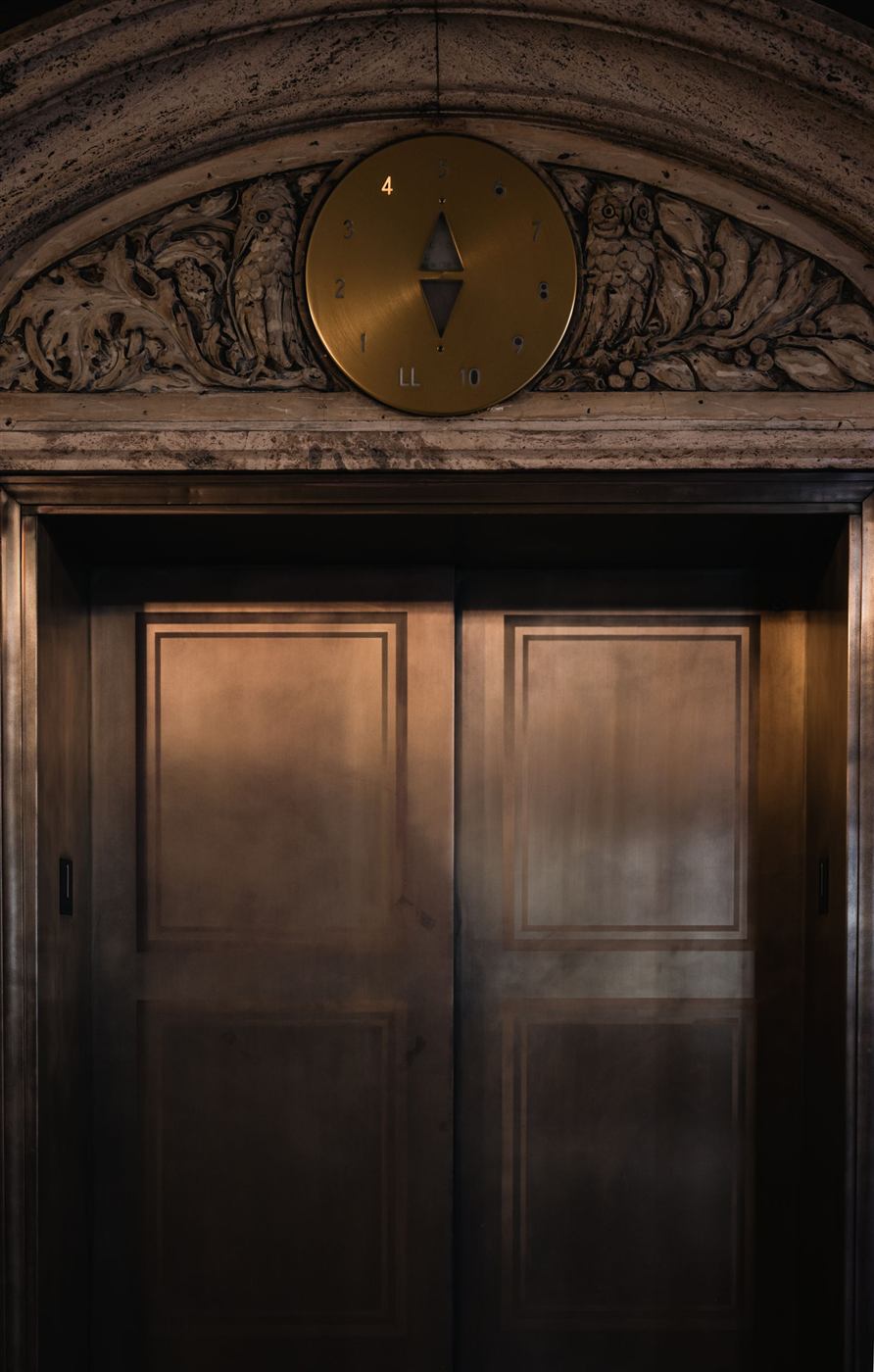 Portes d'ascenseur en laiton ouvragé dans le hall d'un immeuble ancien